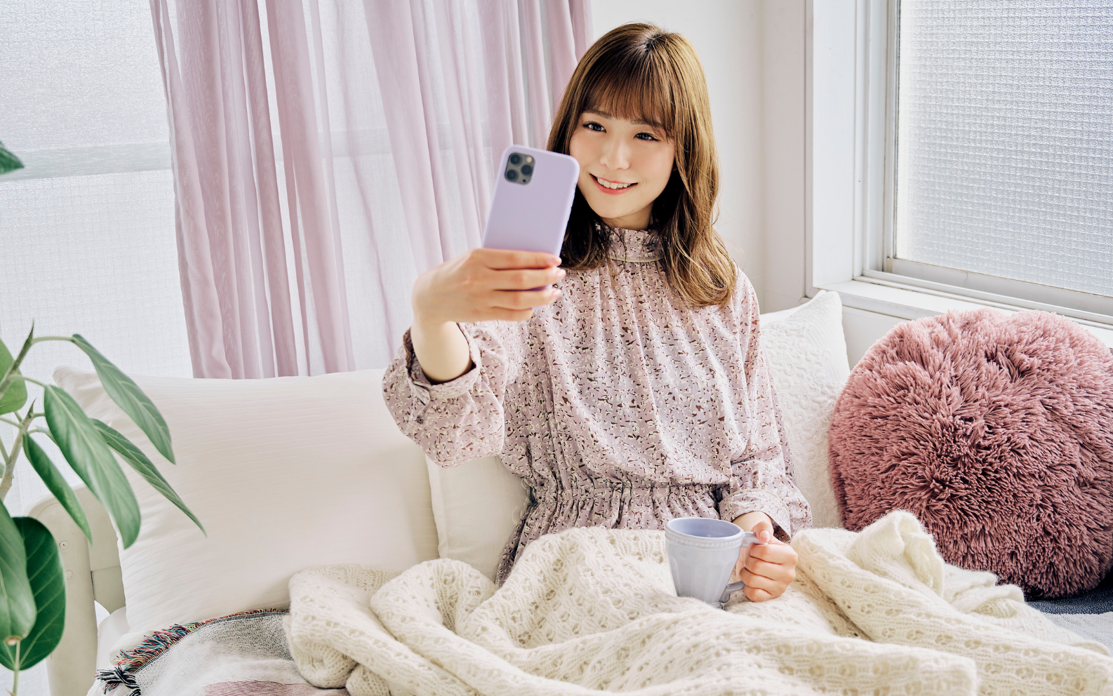 スマホスタンドに設置したスマホでライブ配信をする女性の手元